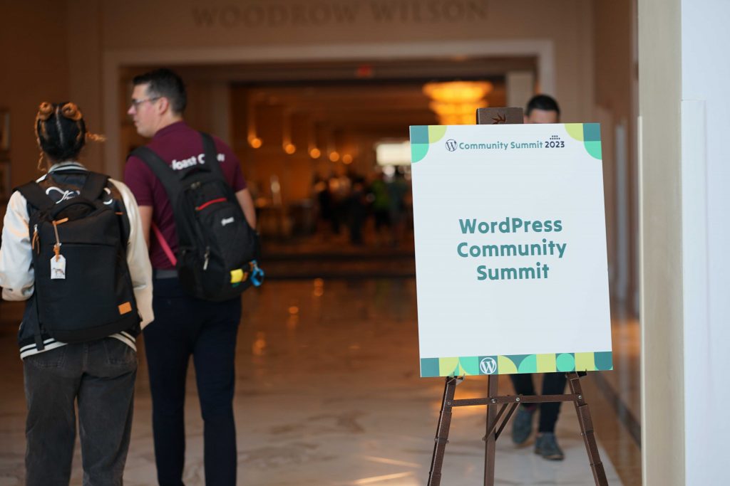 un letrero de la Cumbre de la comunidad de WordPress en la entrada del salón principal de WordCamp US 2023