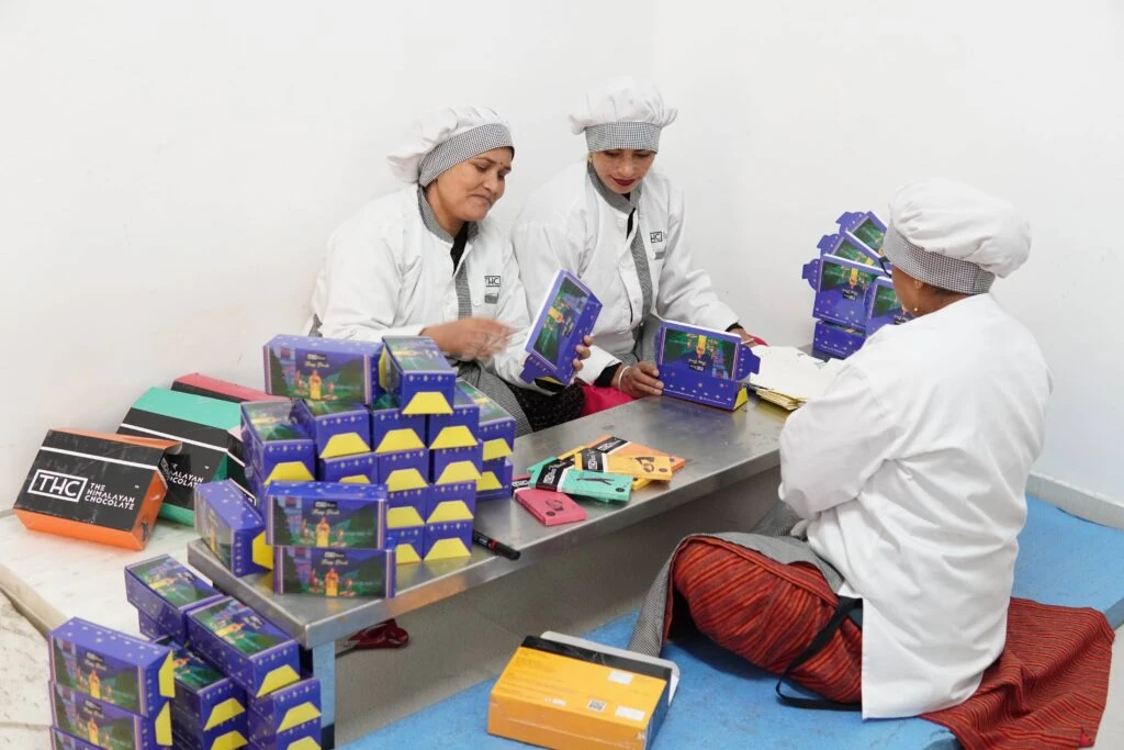 Three women packing chocolates